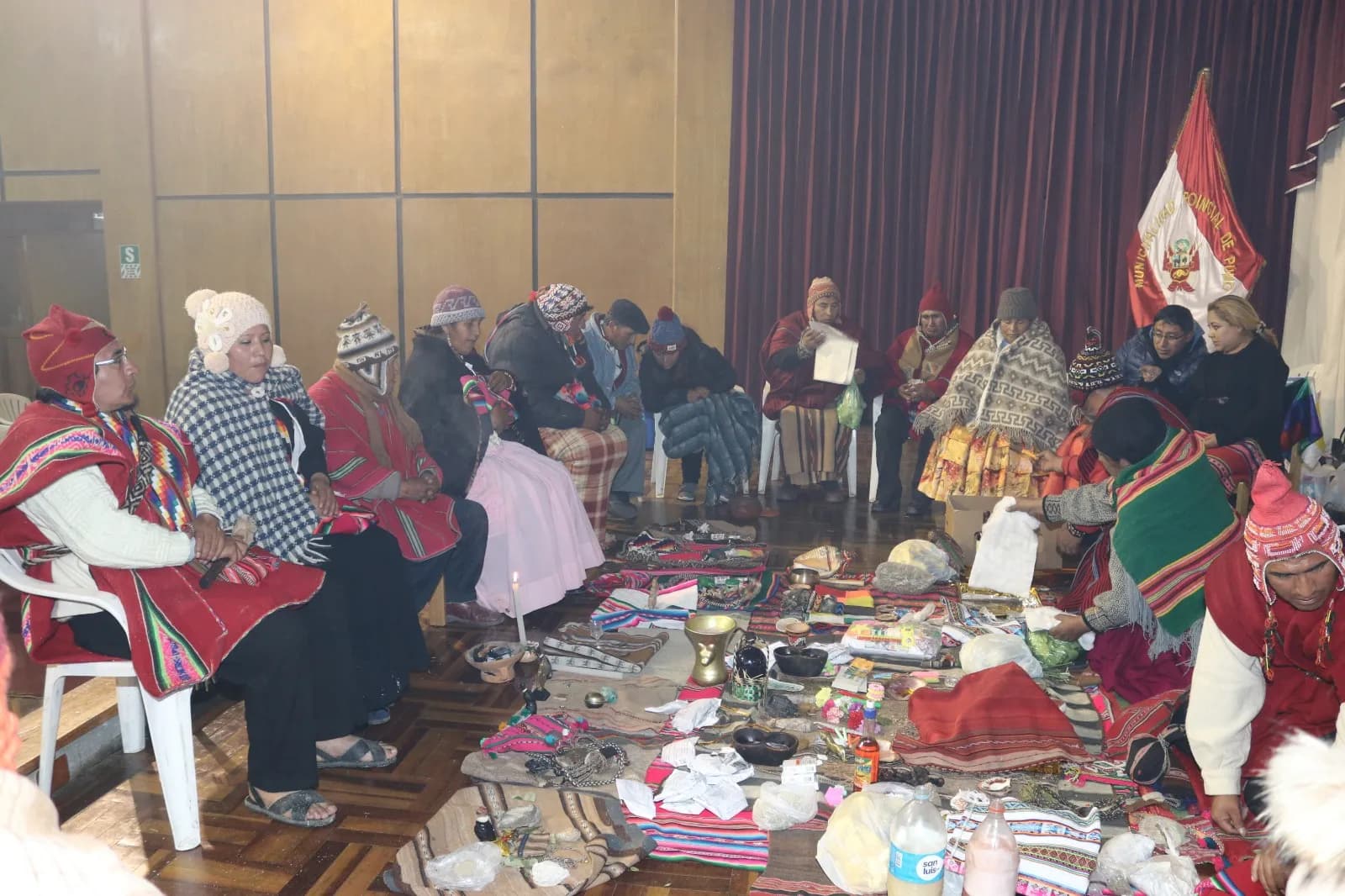Gathering of yatiris and Andean masters seated around ritual mesas