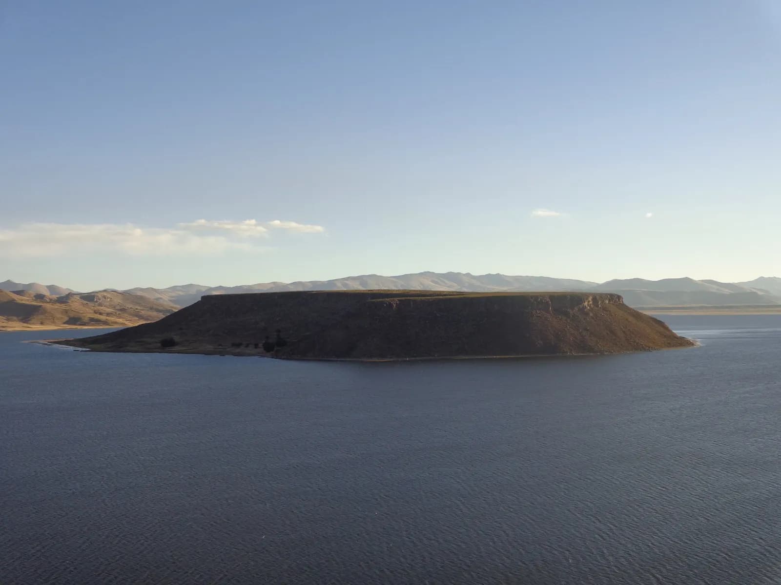 Island on Lake Titicaca at dusk, with the altiplano mountains behind